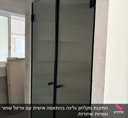 דלת מקלחון זכוכית עם מסגרת שחורה